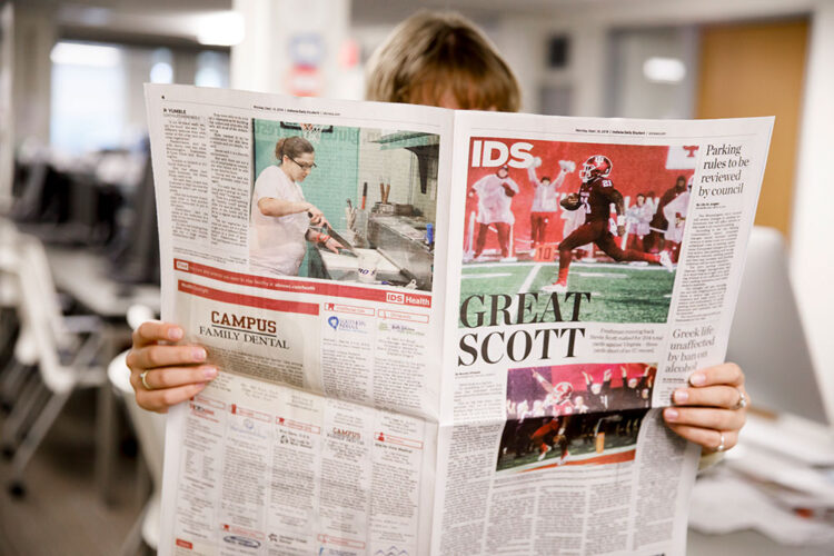 A woman reading the Indiana Daily Student newspaper